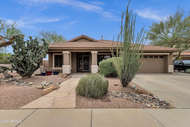 11101 W Wilshire Dr, Avondale, AZ 85392 - view of front of home featuring covered porch, driveway, a tiled roof, a garage, and stucco siding