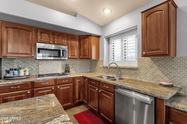 11101 W Wilshire Dr, Avondale, AZ 85392 - kitchen featuring appliances with stainless steel finishes, a sink, vaulted ceiling, dark stone countertops, and backsplash