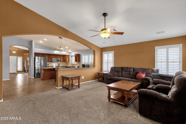 11101 W Wilshire Dr, Avondale, AZ 85392 - living room with arched walkways, lofted ceiling, ceiling fan, light colored carpet, and baseboards