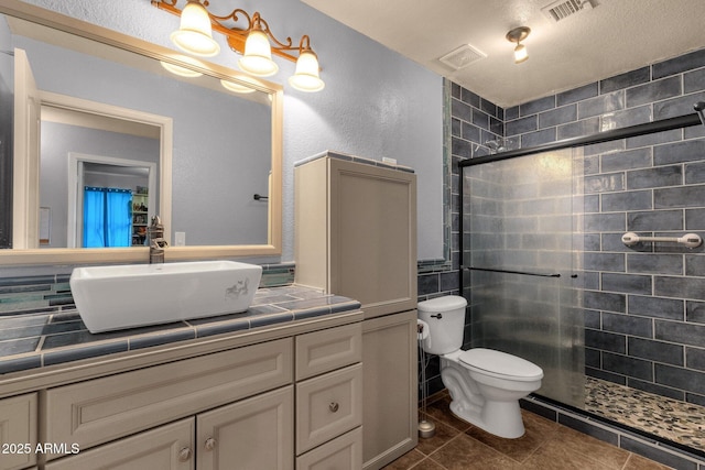 11101 W Wilshire Dr, Avondale, AZ 85392 - full bathroom featuring a stall shower, toilet, vanity, and tile patterned floors