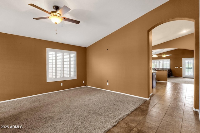 11101 W Wilshire Dr, Avondale, AZ 85392 - tiled empty room featuring lofted ceiling, arched walkways, a ceiling fan, baseboards, and carpet