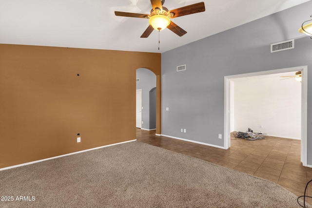 11101 W Wilshire Dr, Avondale, AZ 85392 - carpeted empty room with ceiling fan, arched walkways, tile patterned flooring, vaulted ceiling, and baseboards