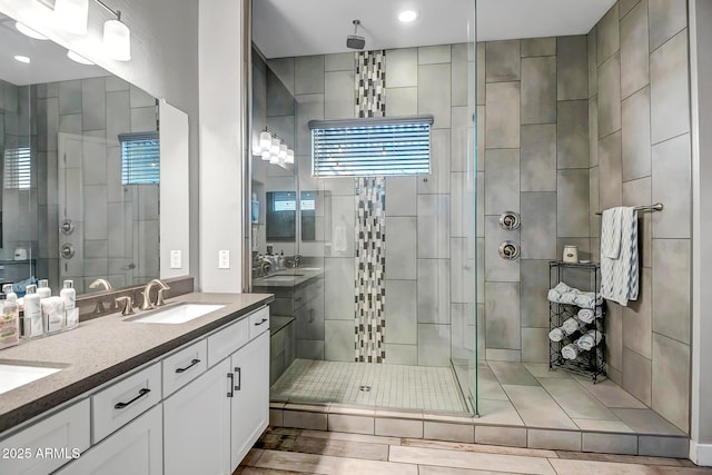 bathroom featuring plenty of natural light, a shower with shower door, and vanity