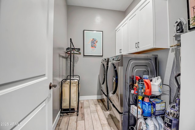 washroom with washer and clothes dryer, light hardwood / wood-style floors, and cabinets