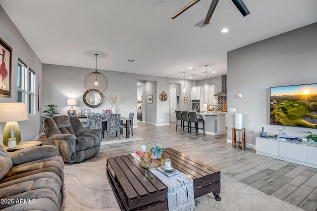 living room with ceiling fan and light hardwood / wood-style floors