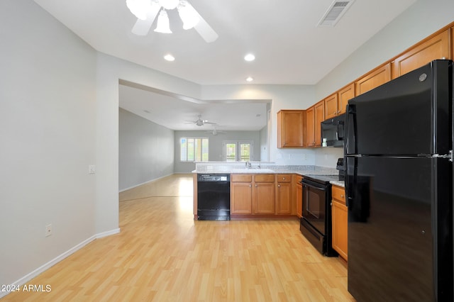 kitchen with light wood-type flooring, black appliances, ceiling fan, and sink