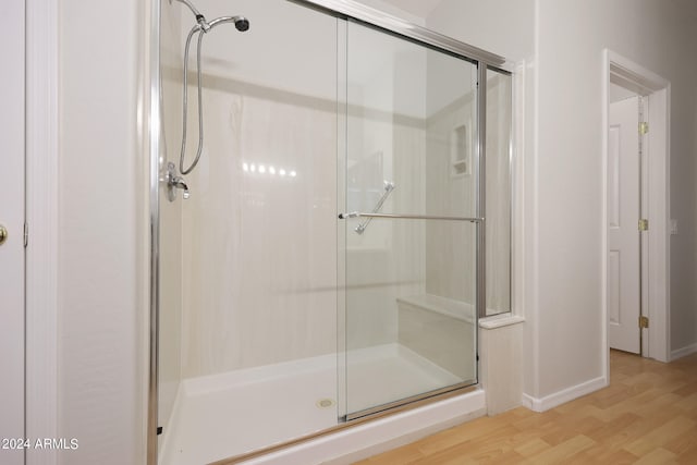 bathroom featuring an enclosed shower and wood-type flooring