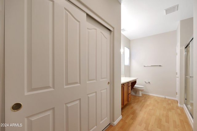 bathroom with vanity, toilet, an enclosed shower, and wood-type flooring