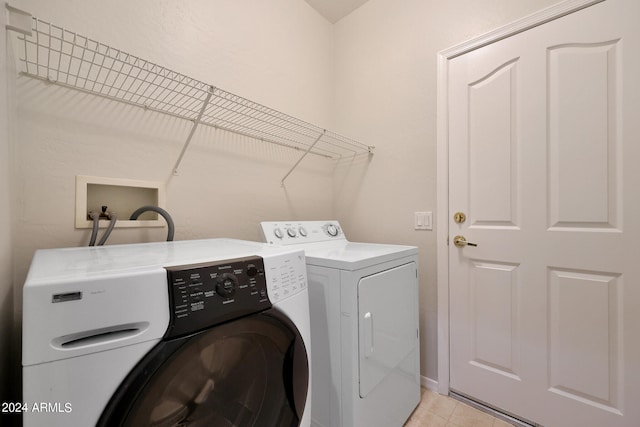 laundry area featuring separate washer and dryer and light tile patterned floors