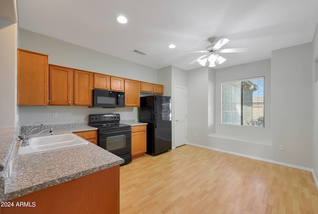 kitchen featuring black appliances, ceiling fan, sink, and light hardwood / wood-style floors