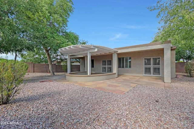 rear view of property featuring a pergola and a patio