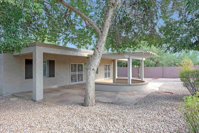 rear view of property featuring a pergola and a patio