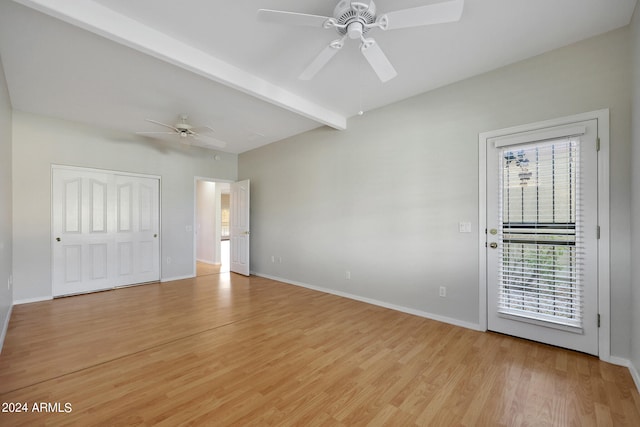 unfurnished room featuring ceiling fan, light wood-type flooring, and beam ceiling