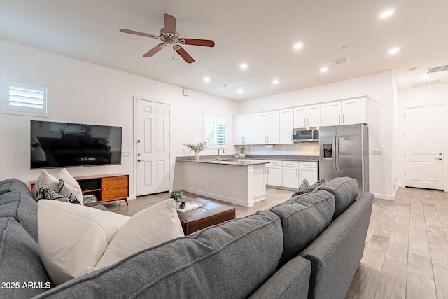 living area with light wood-type flooring, recessed lighting, visible vents, and ceiling fan