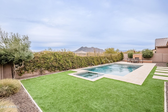 view of pool featuring a fenced backyard, a pool with connected hot tub, a lawn, and a patio