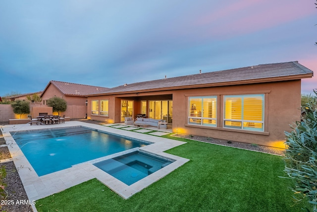 rear view of property with a patio, a fenced backyard, an in ground hot tub, an outdoor living space, and stucco siding