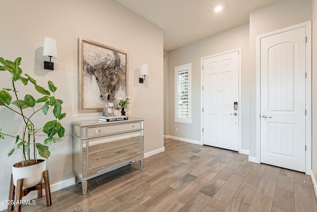 foyer with light wood-style floors and baseboards