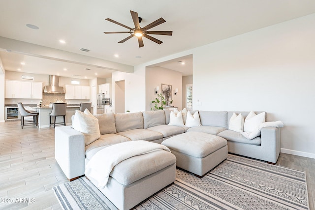 living room featuring wine cooler, light wood finished floors, recessed lighting, ceiling fan, and baseboards