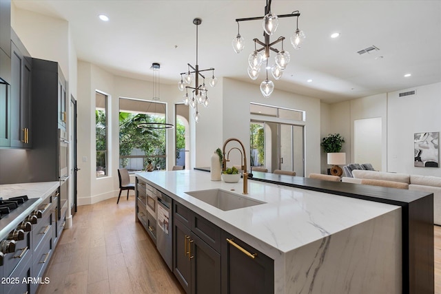 kitchen with recessed lighting, visible vents, a sink, and light wood finished floors