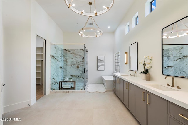 full bathroom with a sink, a marble finish shower, a towering ceiling, and a chandelier