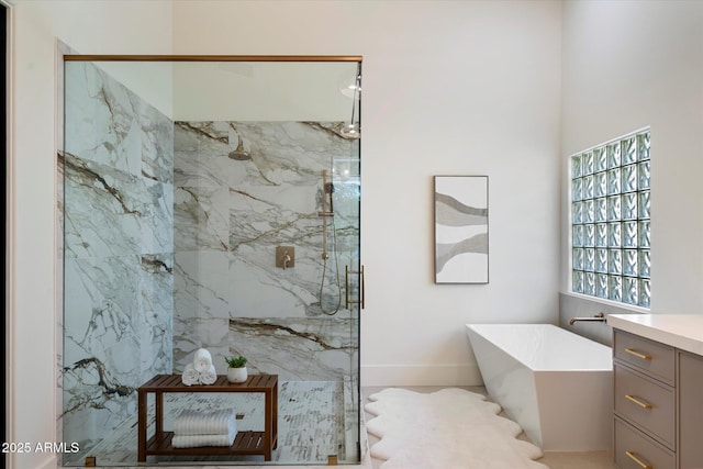full bath featuring a freestanding bath, a marble finish shower, and vanity