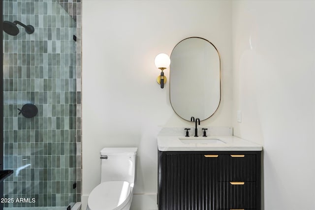 bathroom featuring toilet, a tile shower, and vanity