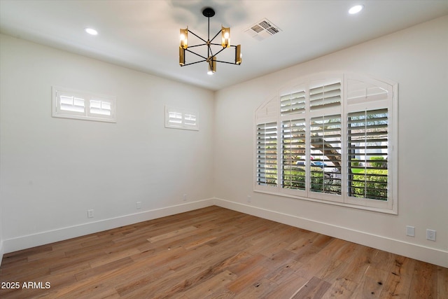 spare room featuring visible vents, baseboards, light wood finished floors, a chandelier, and recessed lighting