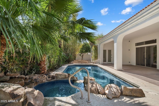 outdoor pool featuring french doors and a patio