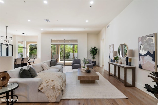 living area featuring recessed lighting, baseboards, visible vents, and wood finished floors