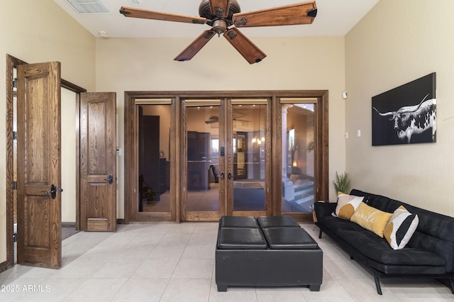 tiled living room featuring french doors and ceiling fan