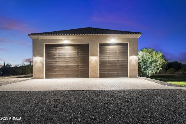 view of garage at dusk