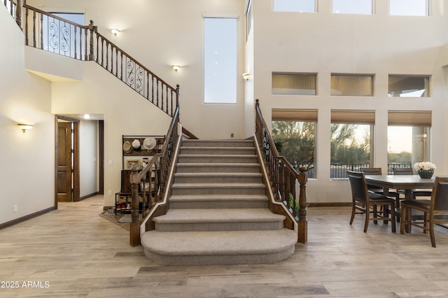 staircase featuring hardwood / wood-style flooring and a towering ceiling