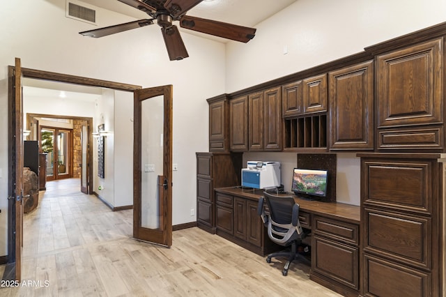 office featuring light hardwood / wood-style flooring, built in desk, french doors, and ceiling fan