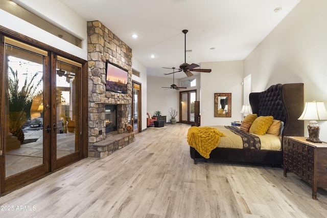 bedroom with french doors, access to outside, ceiling fan, a fireplace, and light hardwood / wood-style floors