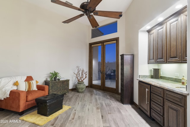 kitchen with french doors, ceiling fan, dark brown cabinetry, and light wood-type flooring