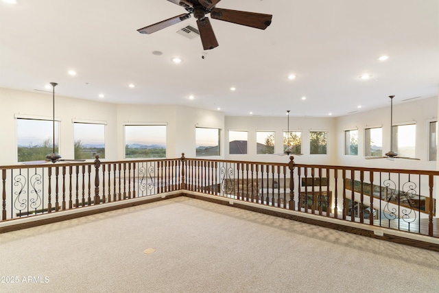 empty room with carpet floors, a healthy amount of sunlight, and ceiling fan