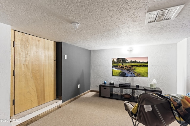 carpeted cinema room featuring a textured ceiling