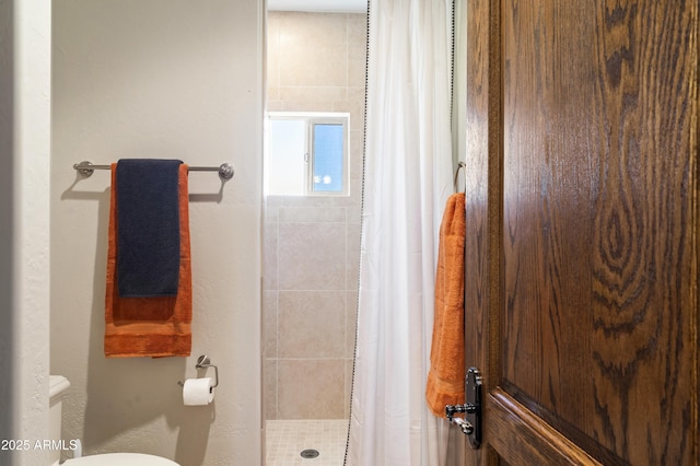 bathroom featuring a shower with curtain and toilet