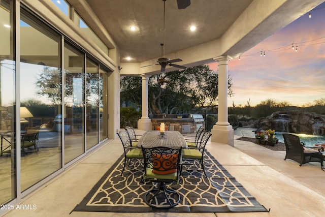 patio terrace at dusk featuring area for grilling and ceiling fan