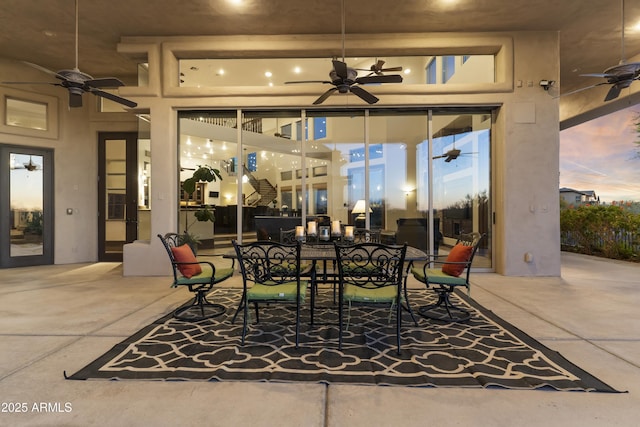 patio terrace at dusk featuring ceiling fan