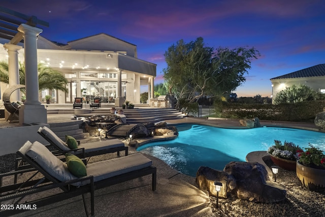 pool at dusk featuring a patio