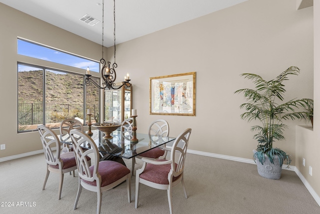 dining space with carpet flooring, a healthy amount of sunlight, and a notable chandelier