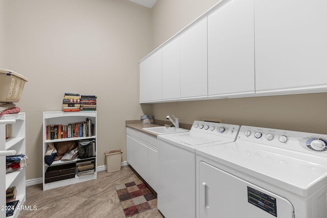 laundry area featuring cabinets, separate washer and dryer, and sink