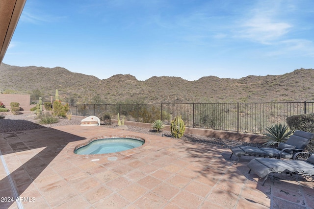 view of swimming pool featuring a patio, a mountain view, and an in ground hot tub