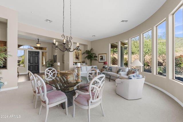 dining room featuring a wealth of natural light, a chandelier, and light carpet