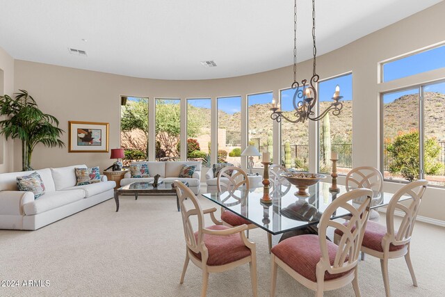 carpeted dining room with a chandelier and plenty of natural light