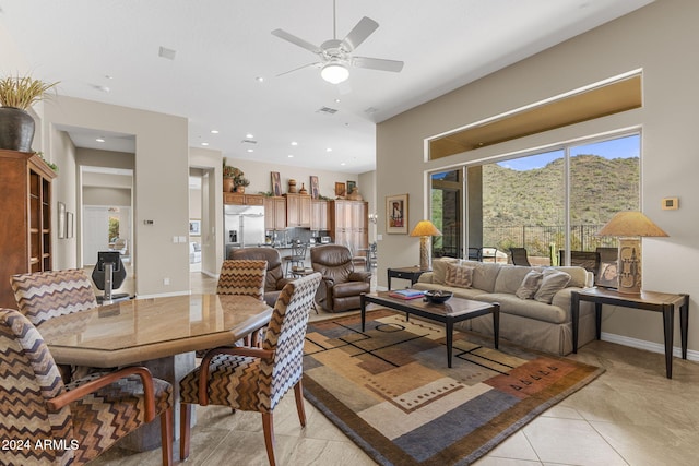 living room featuring a mountain view, light tile patterned floors, and ceiling fan