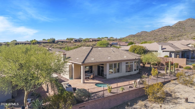 rear view of property with a mountain view and a patio