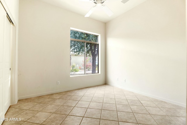 tiled spare room with ceiling fan