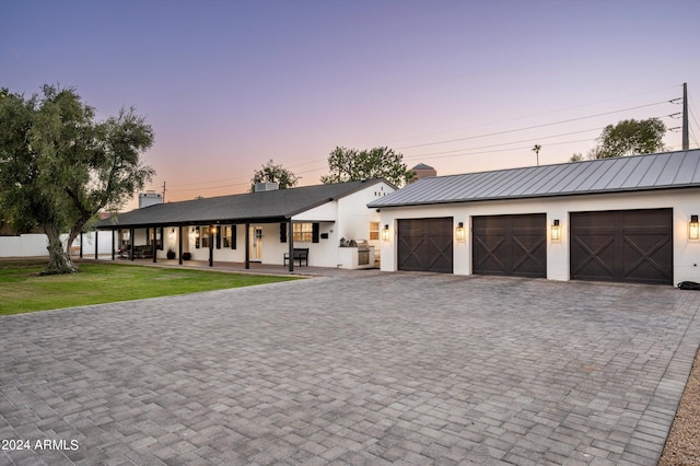 view of front of house with a garage and a lawn